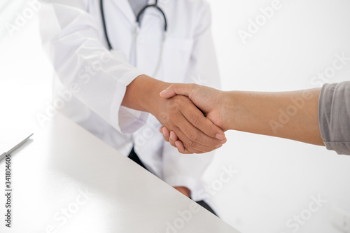 Doctors and patients shaking hands after knowing the results of the health examination, medical checkup concept