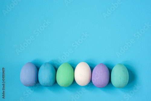 Multicolored eggs of bed colors on a blue background