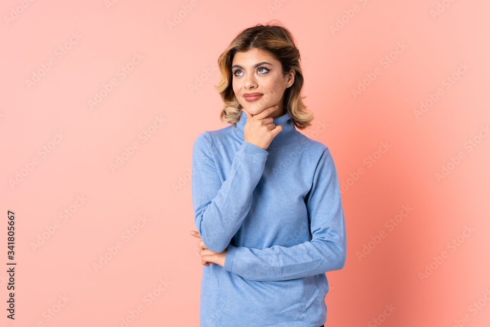 Young Russian woman isolated on pink background having doubts while looking up Young Russian woman isolated on pink background having doubts while looking up