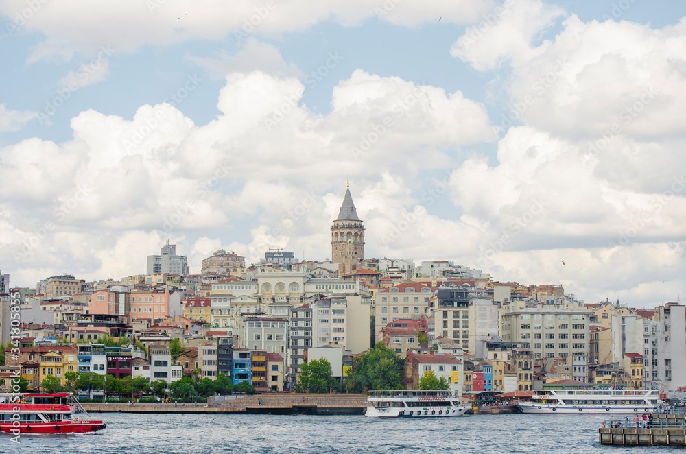 Fototapeta premium Galata Tower. View of famous historic landmark across Golden Horn. Popular tourist destination. Cloudy. Turkey, Istanbul, Bosphorus