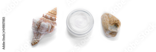 Facial cream and sea shell and stone on the isolated white background.