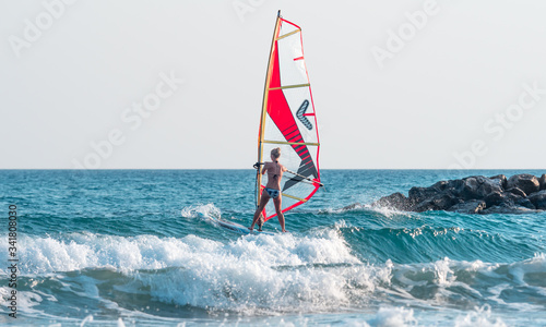 a windsurfer trying hard to pass small waves
