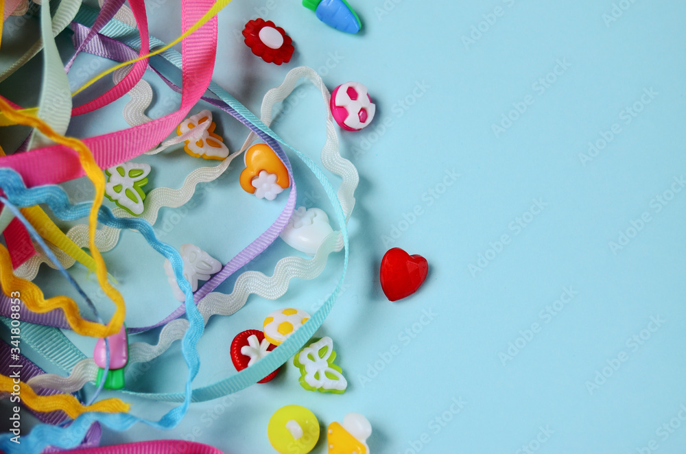 cotton ribbons and buttons against a mint color background with copy space
