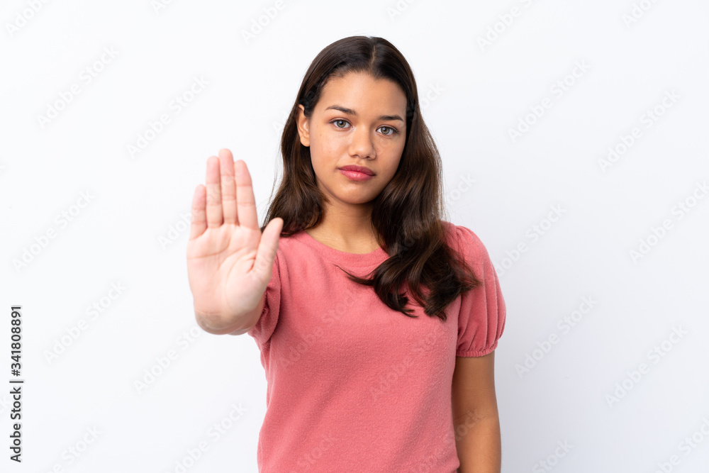 Young Colombian girl over isolated white background making stop gesture Young Colombian girl over isolated white background making stop gesture