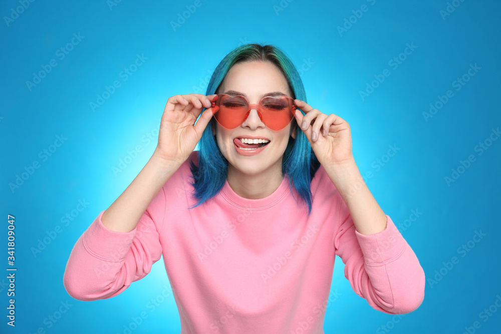 Young woman with bright dyed hair on light blue background Young woman with bright dyed hair on light blue background