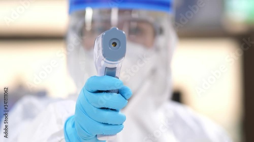 Wallpaper Mural Doctor wearing PPE suit use Thermometer Gun Medical Digital Non-Contact Infrared Sight Handheld Forehead Readings,Coronavirus has turned into a global emergency,Coronavirus Disease 2019 (COVID-19). Torontodigital.ca