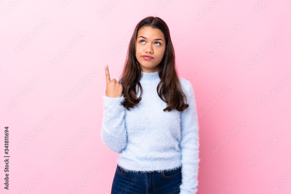 Young Colombian girl over isolated pink background pointing with the index finger a great idea Young Colombian girl over isolated pink background pointing with the index finger a great idea