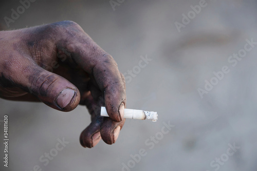 Cigarette addiction of a person with dirty hands