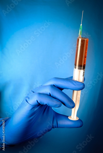 Фотография Health worker with rubber gloves and a syringe with liquid drugs in the barrel