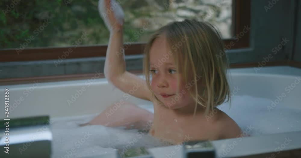 Preschooler in bathtub with his mother putting bubbles on his head Preschooler in bathtub with his mother putting bubbles on his head