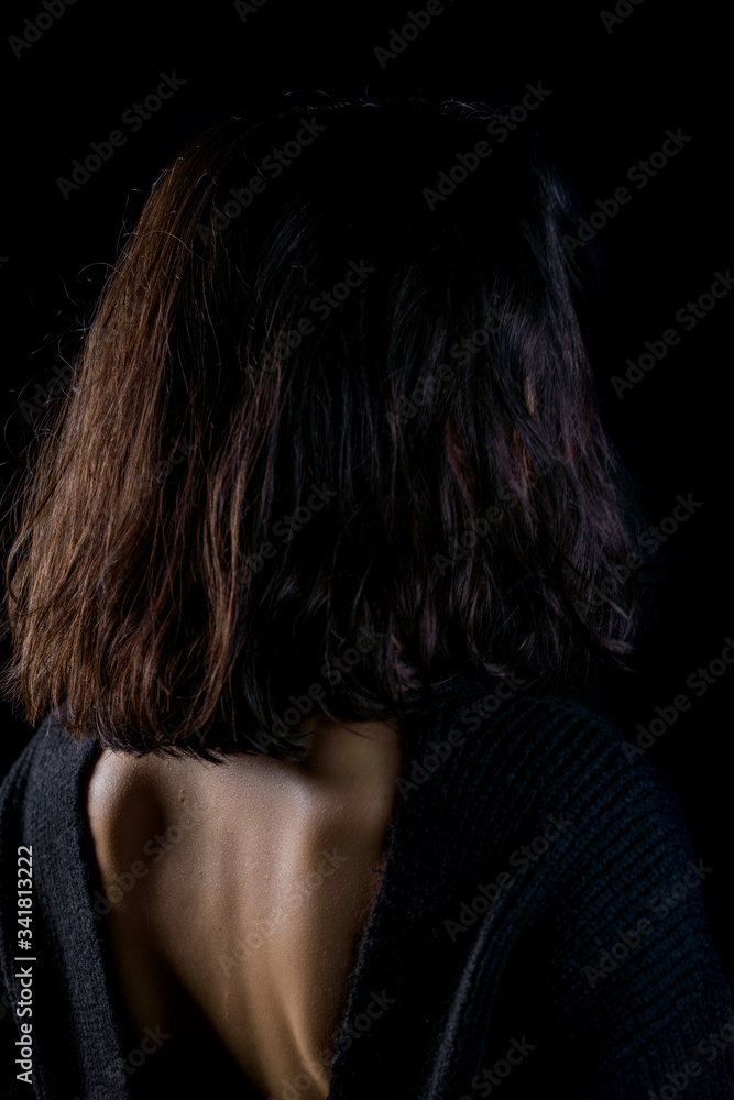 Close-up detail photo of young woman wearing open back blouse on black background Close-up detail photo of young woman wearing open back blouse on black background