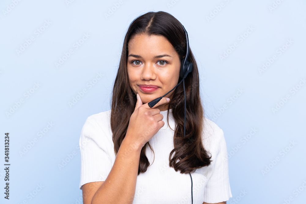 Young telemarketer Colombian woman over isolated blue background laughing Young telemarketer Colombian woman over isolated blue background laughing