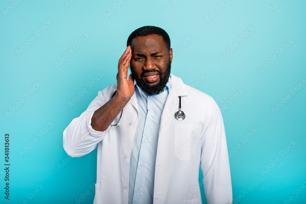 Doctor is exhausted due to overwork by coronavirus covid-19. Cyan background Doctor is exhausted due to overwork by coronavirus covid-19. Cyan background