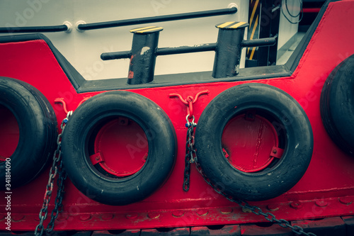 Old car tires on board a ship. Rubber wheels protect the boat from impact. Steel lining of the side of the tugboat.