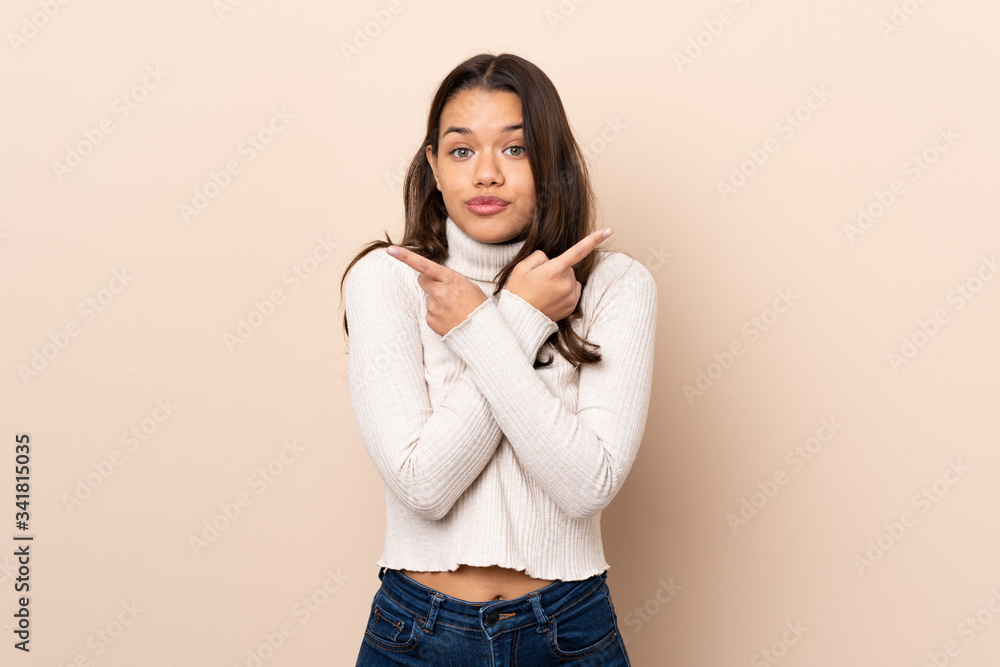 Young Colombian girl over isolated background pointing to the laterals having doubts Young Colombian girl over isolated background pointing to the laterals having doubts