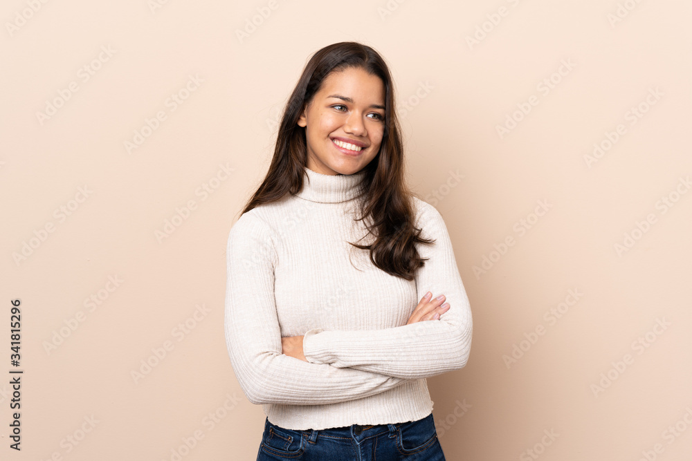Young Colombian girl over isolated background with arms crossed and happy Young Colombian girl over isolated background with arms crossed and happy