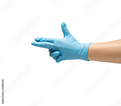 Female hands in protective rubber gloves of blue color show a gun sign on white background isolate.