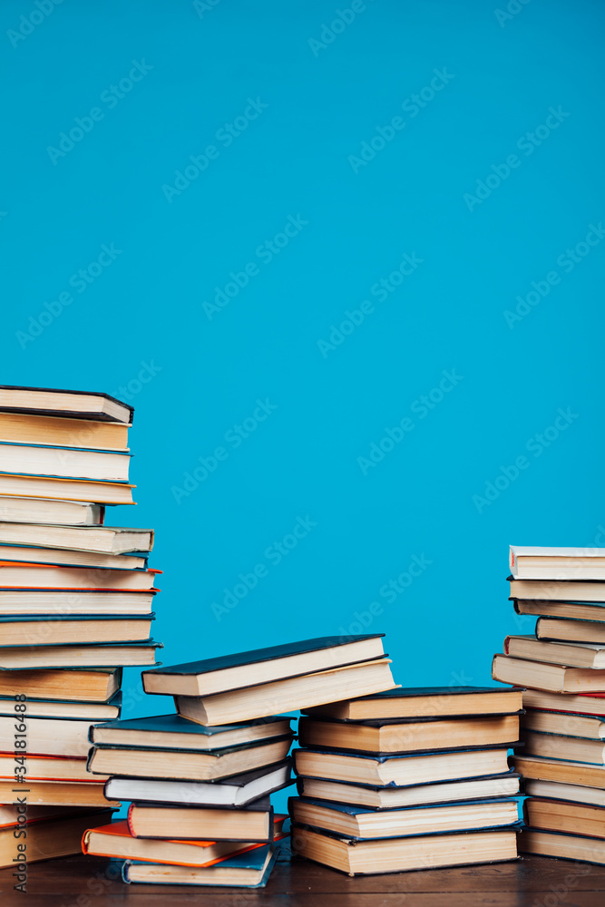 a lot of stacks of educational books in the college library on a blue background a lot of stacks of educational books in the college library on a blue background