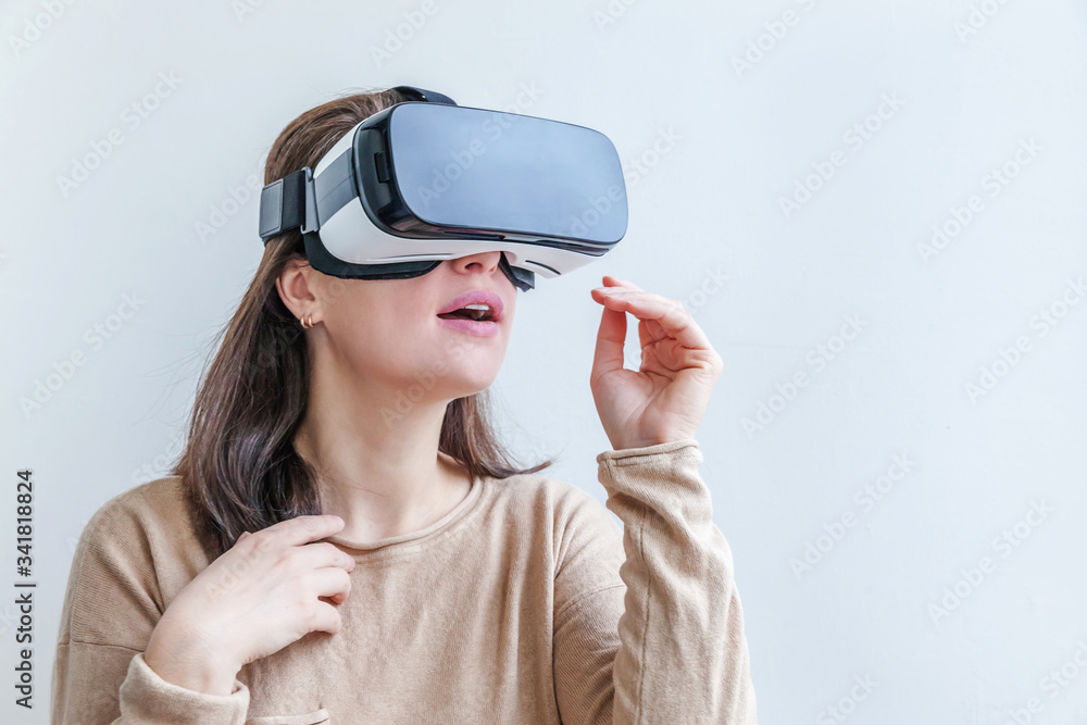 Smile young woman wearing using virtual reality VR glasses helmet headset on white background. Smartphone using with virtual reality goggles. Technology, simulation, hi-tech, videogame concept. Smile young woman wearing using virtual reality VR glasses helmet headset on white background. Smartphone using with virtual reality goggles. Technology, simulation, hi-tech, videogame concept.