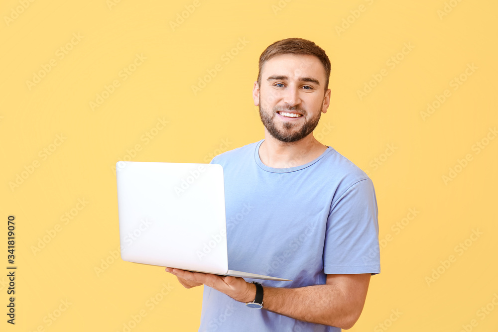 Male programmer with laptop on color background Male programmer with laptop on color background