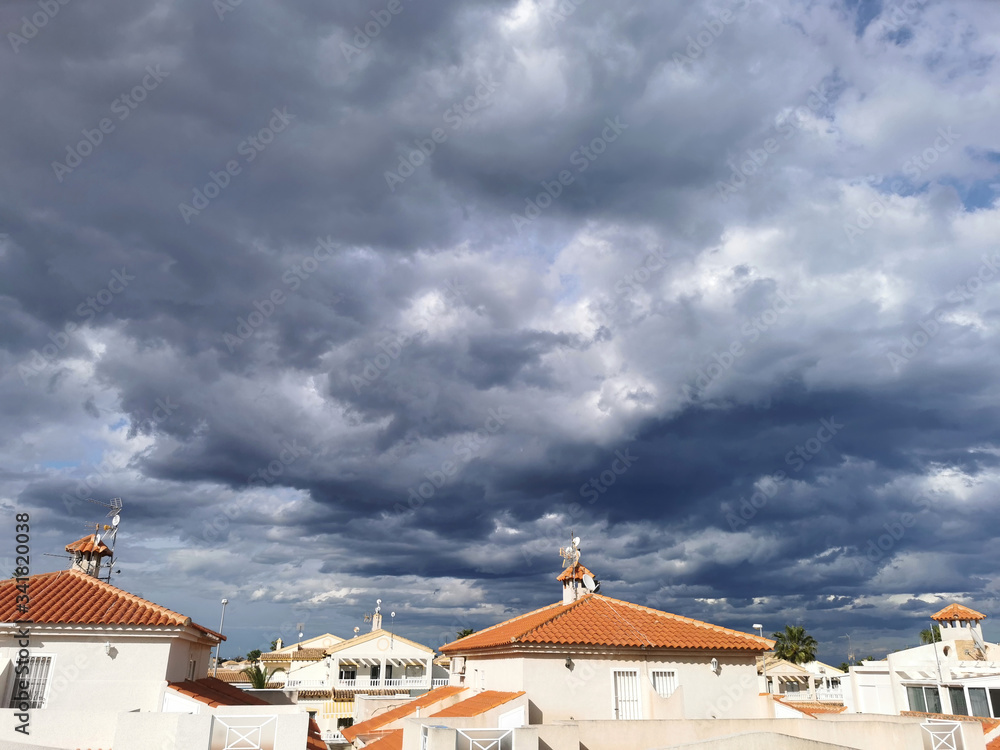 panorama of the town against the backdrop of a huge sky with large thunderclouds