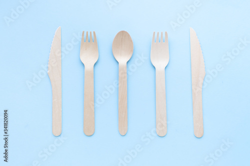 eco friendly disposable kitchenware utensils on blue background. wooden forks and spoons. ecology, zero waste concept. top view. flat lay.