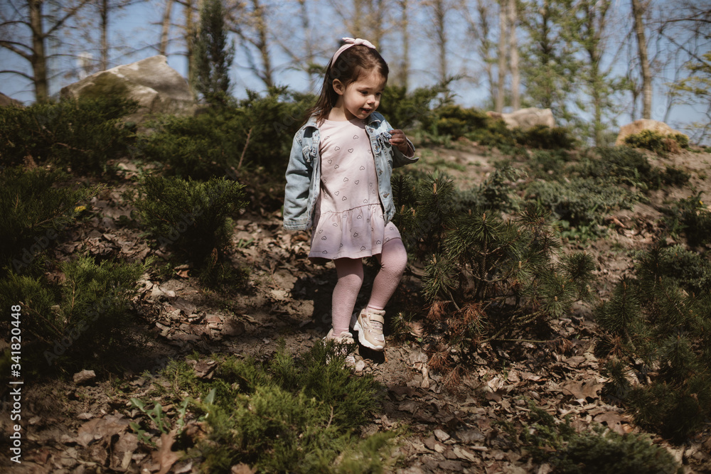 child playing in the spring park among the trees child playing in the spring park among the trees