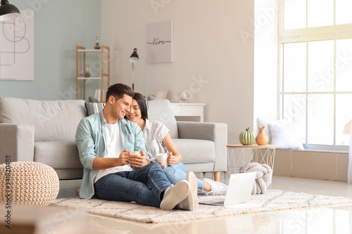 Happy young couple with lap...