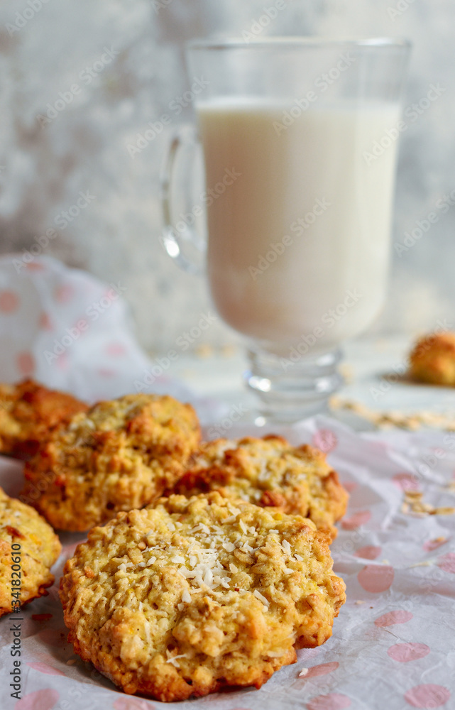Oatmeal cookies and a glass of milk. Light wooden background. Healthy sweet breakfast. Free space for text. Close up. Vertical view Oatmeal cookies and a glass of milk. Light wooden background. Healthy sweet breakfast. Free space for text. Close up. Vertical view