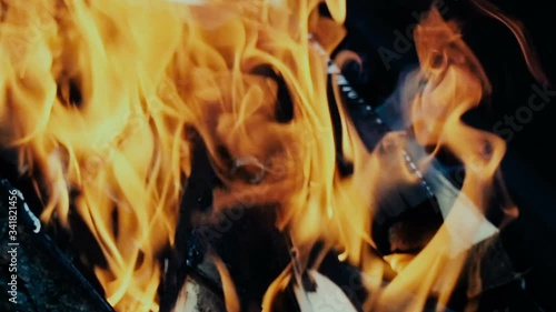 Close-up shot on wood burning with an orange flame of fire