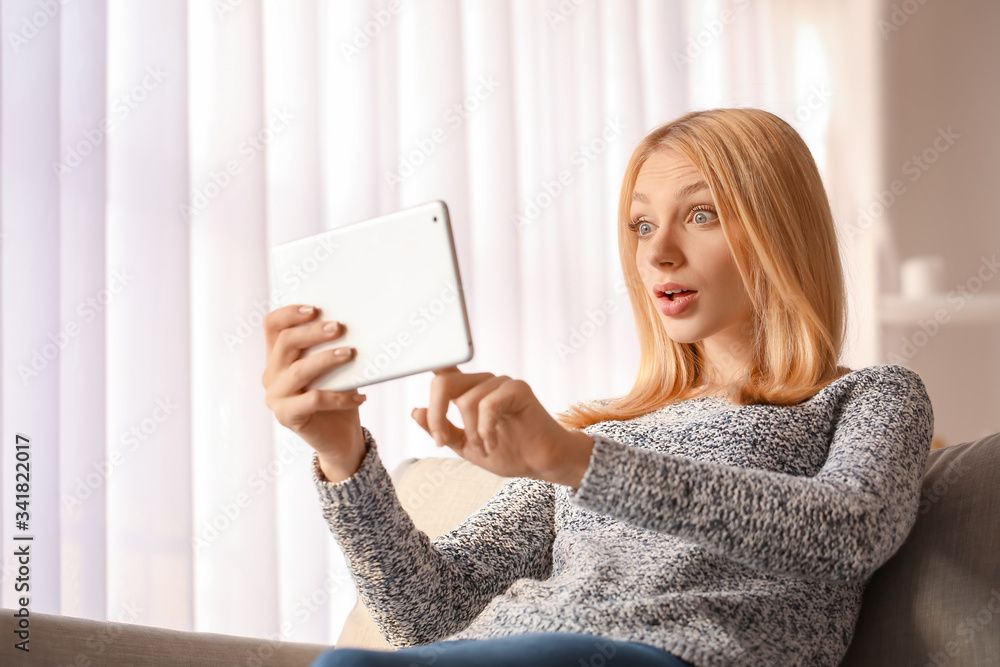 Surprised young woman with tablet computer at home Surprised young woman with tablet computer at home