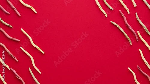 Italian fileja pasta on red background. Flat lay in diagonal order. 4K stop motion animation seamless loop