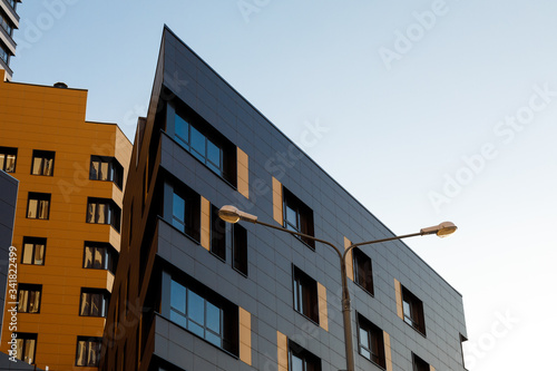 Fragment of a new elite residential building or commercial complex. Part of urban real estate. Modern ventilated facade with windows. Diagonal arrangement.