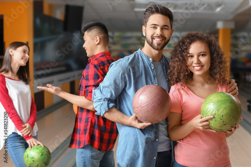 Friends playing bowling in ...
