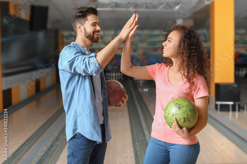 Friends playing bowling in ...