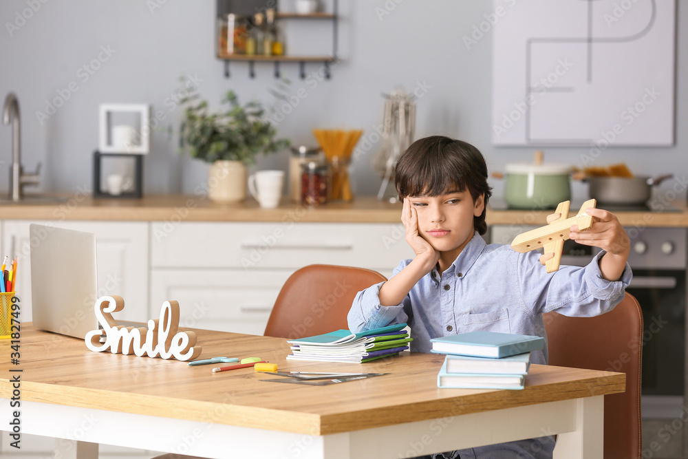 Little boy unwilling to do homework in kitchen Little boy unwilling to do homework in kitchen