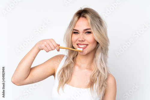 Teenager blonde girl over isolated white background with a toothbrush
