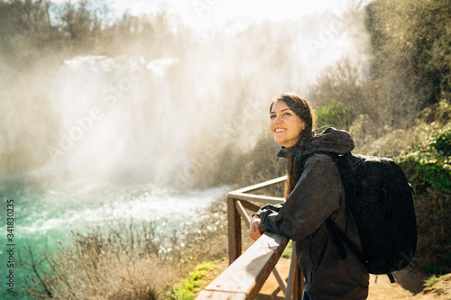 Woman tourist hiker visiting a mountain national park waterfall trail.Adventure tourist exploring nature.Nature and environment lover.Healthy lifestyle,enjoying outdoor activity vacation.