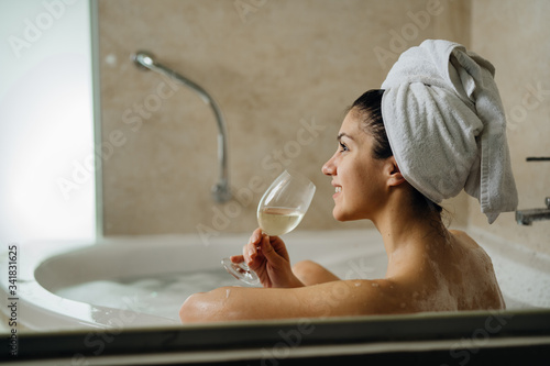 Murais de parede Woman relaxing at home in the hot tub bath ritual,drinking wine