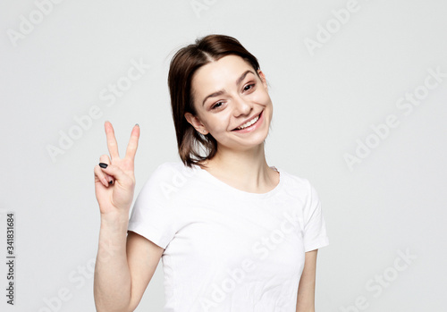 lifestyle and people concept: lovely woman showing victory or peace sign