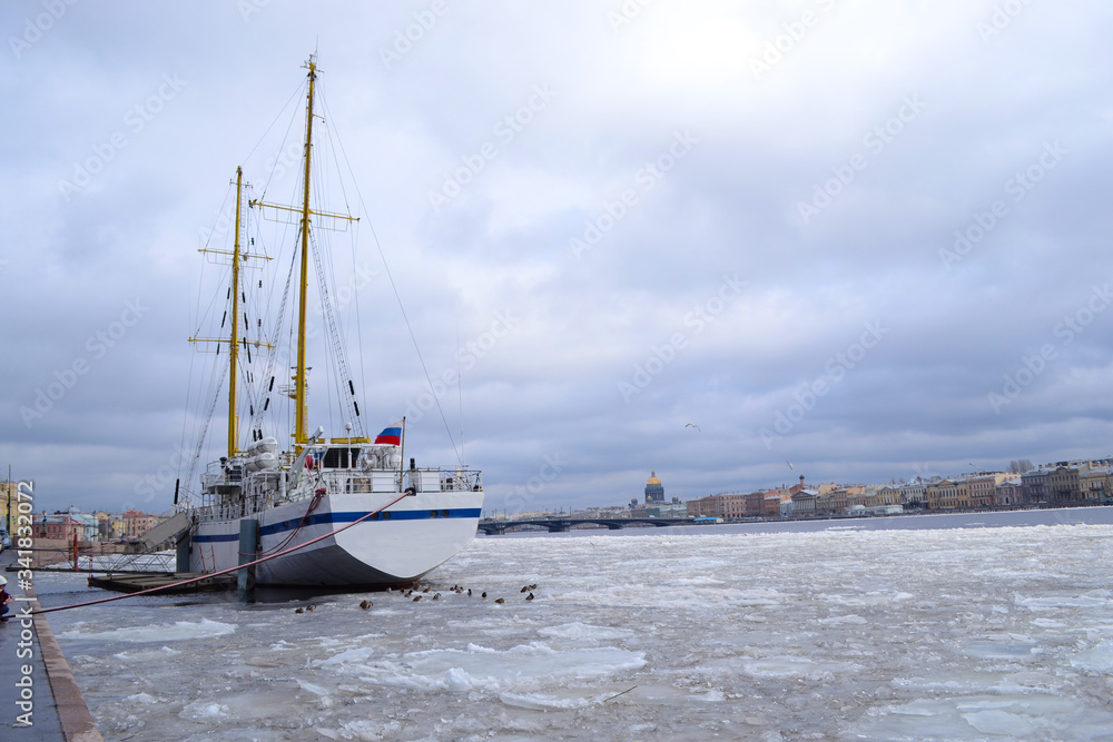 A sailing ship stands in winter in the port on the Neva river in Saint Petersburg
