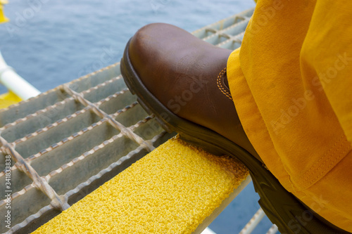 Close up of industry steel staircase with yellow anti slip plate with safety shoe step on the tread.