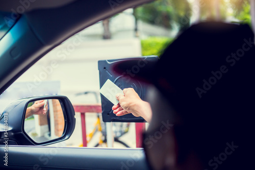Selective focus to driver hold card to scan at card reader station for open the car park door.