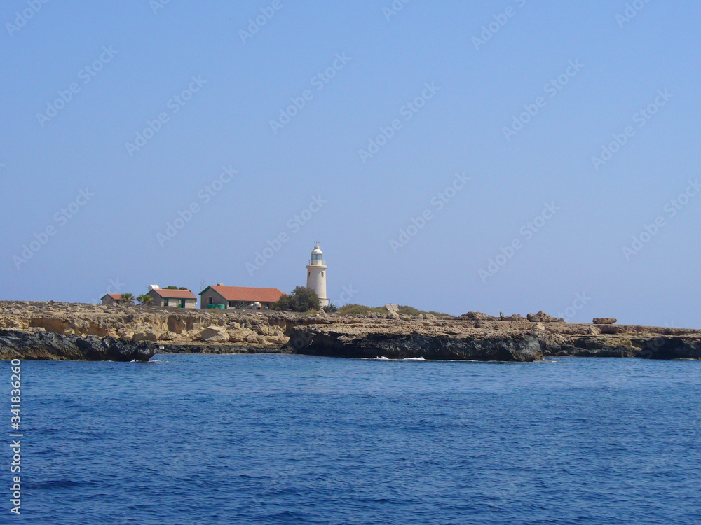 The white lighthouse stands near the sea