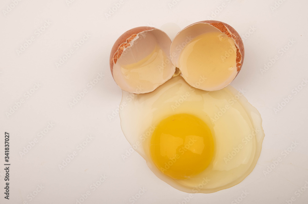 A broken chicken egg on a white background. Close up. A broken chicken egg on a white background. Close up.