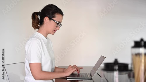 Young millennial woman working from home on her laptop smiling. Smart working