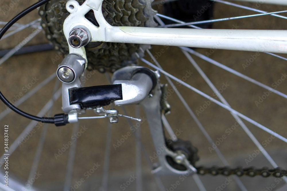 Fototapeta premium Old mountain bike against the wall. Repair of retro bicycles. Bicycle as a means of preserving health. Rear derailleur of the close-up.
