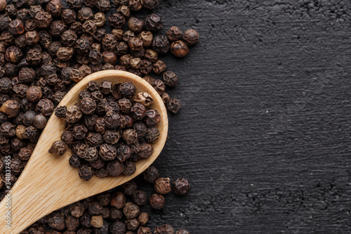 Peppercorn background. Dry black pepper seeds. Top view.On a black background. free space for your text.