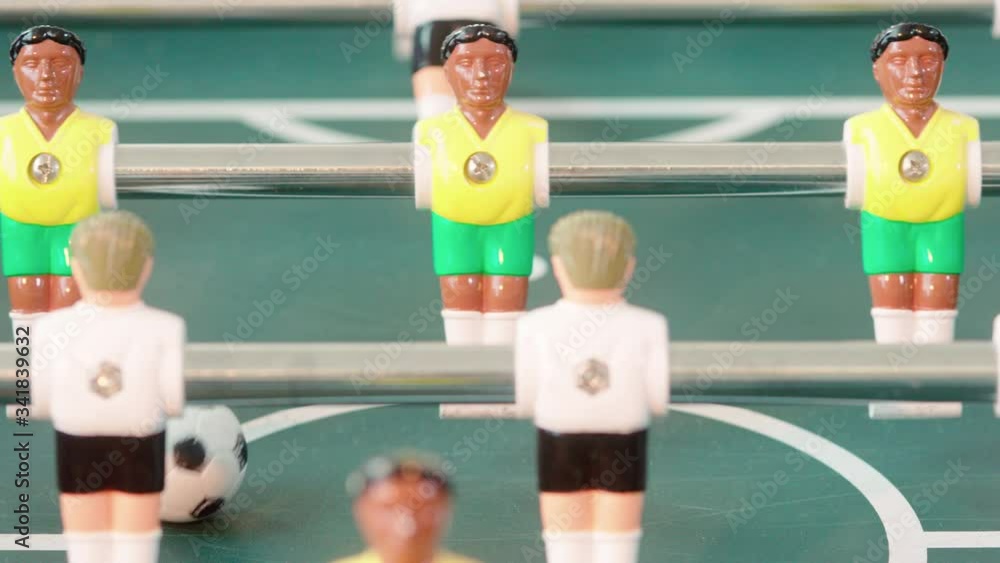 Close up of table soccer game miniatur football germany vs brasil white versus yellow shot in 4k