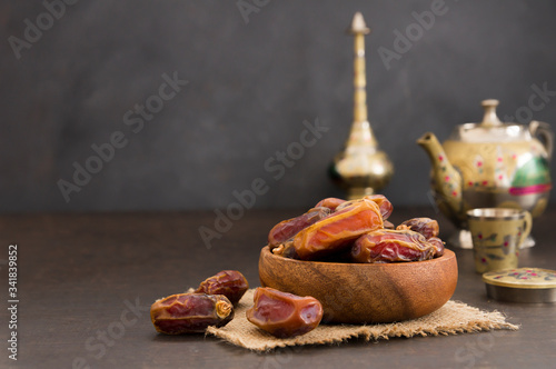 Ramadan kareem with dried dates and authentic metal zamzam water carafe, blessed mounth concept, copy space selective focus photo